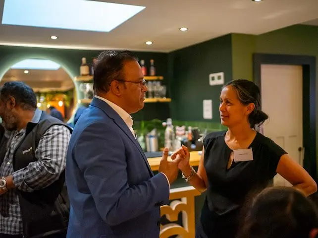 Sabbir Karim talking with guests at an evening event