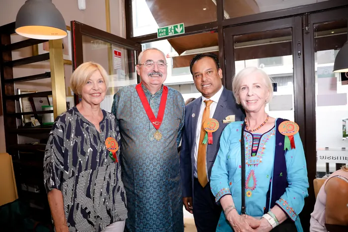 Sabbir Karim with three guests wearing celebration rosettes